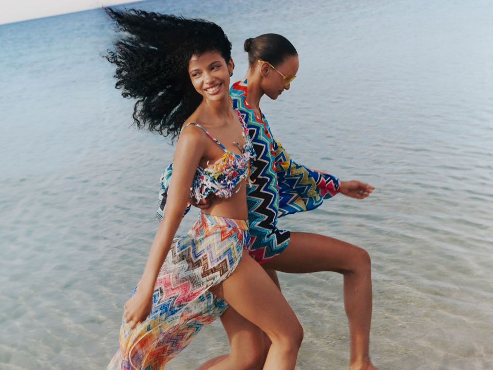 Two models are wearing a multicolour zigziag cover up from the Missoni beachwear collection