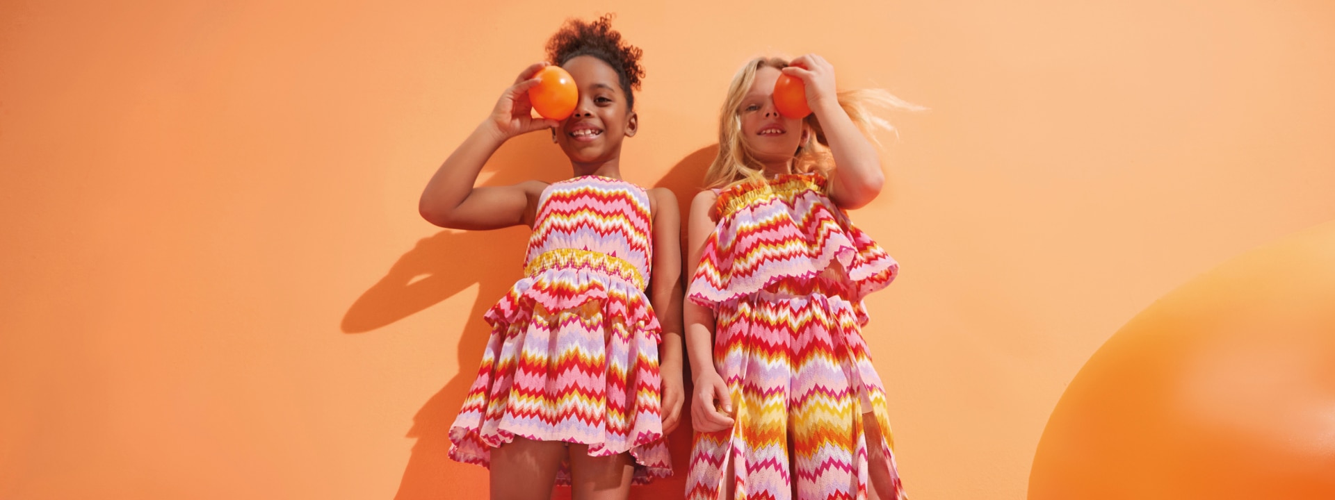 Two girls are wearing zig zag outifts from the new Missoni Kidswear collection