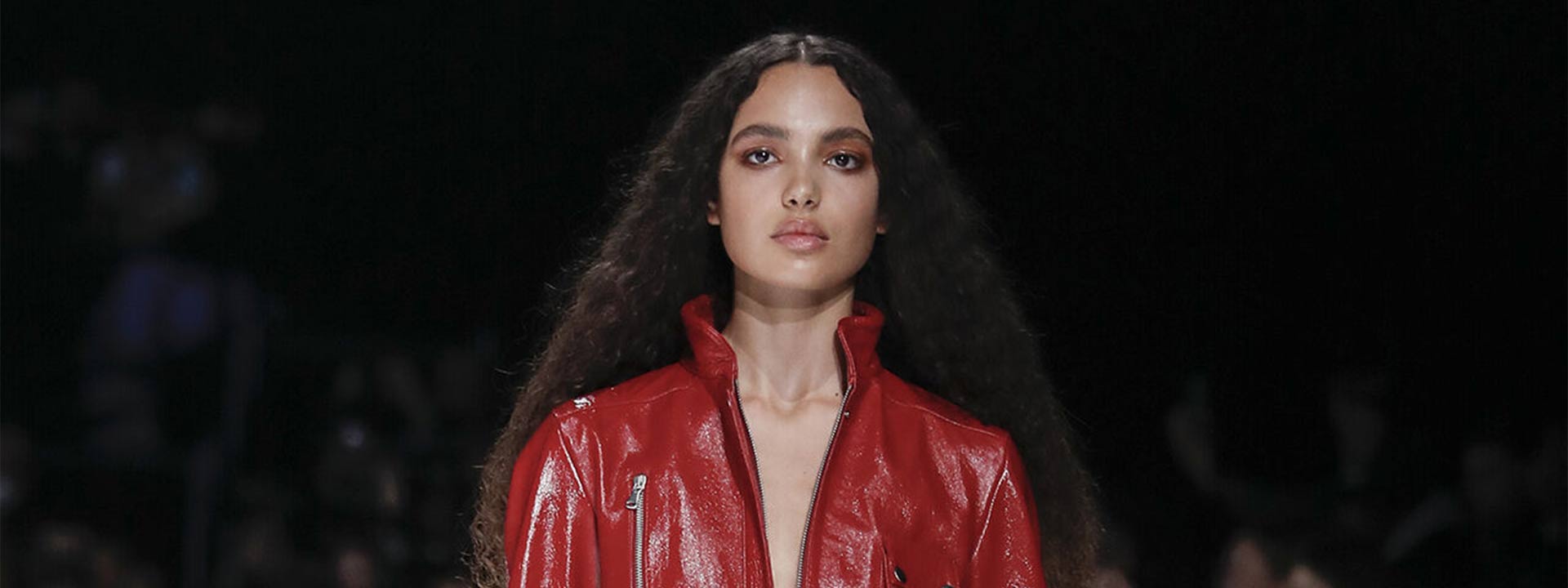 A model is wearing a red jumpsuit from the Fall Winter 2022 collection