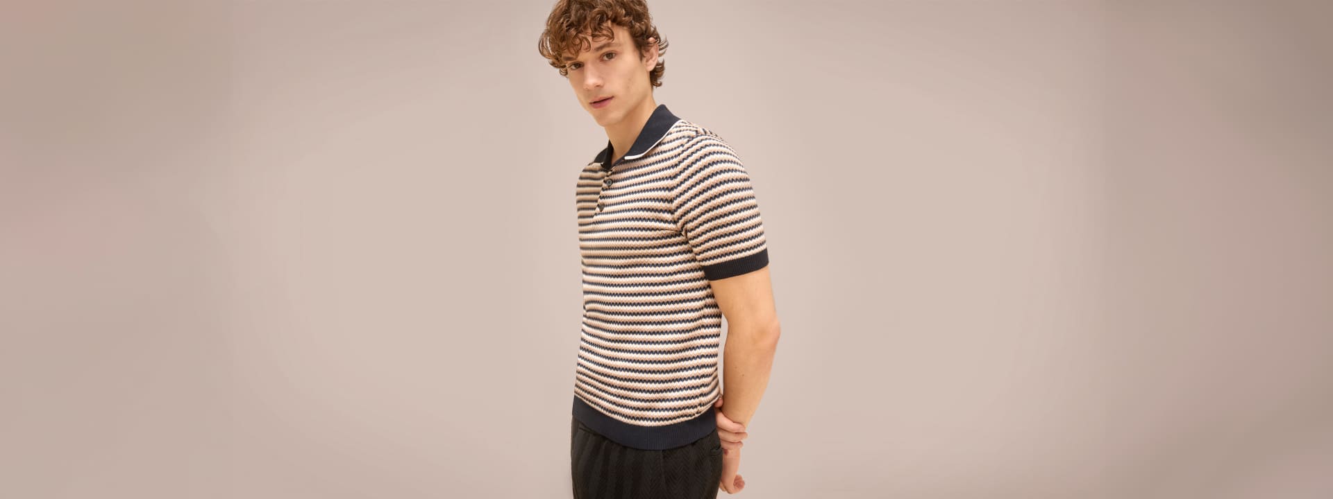 A model is wearing a white and blue polo