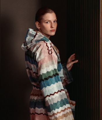 A model is wearing a sleeveless tank top and a pair of trousers, both in zig zag textures