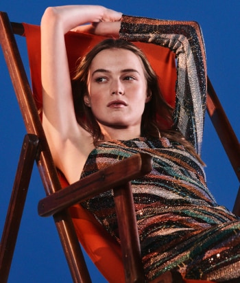 A model is wearing a strapless short dress in brown tones