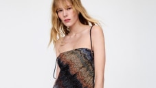 A model is wearing a strapless short dress in brown tones