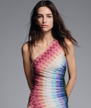 A model is wearing a two pieces jumpsuits, with a sleeveless top and a pair of long trousers, in brown striped tones