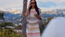 A woman is wearing a zig zag knitwear in pink tones