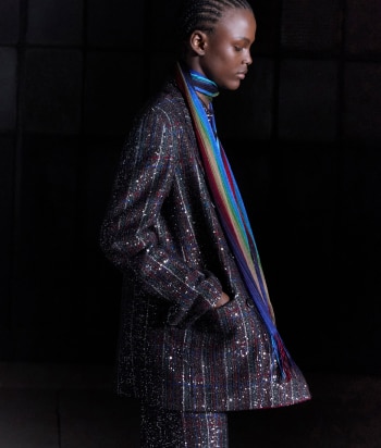 A model is wearing a sleeveless tank top and a pair of trousers, both in zig zag textures