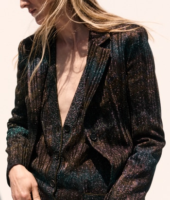 A model is wearing a sleeveless tank top and a pair of trousers, both in zig zag textures