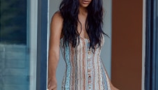 A model is wearing a cardigan dress in light colors