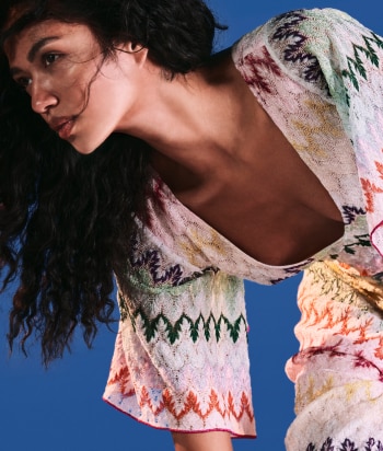 A model is wearing a two pieces jumpsuits, with a sleeveless top and a pair of long trousers, in brown striped tones
