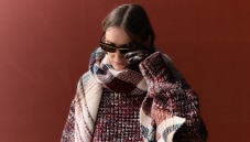 A model is wearing a sparkling jacket in dark tones