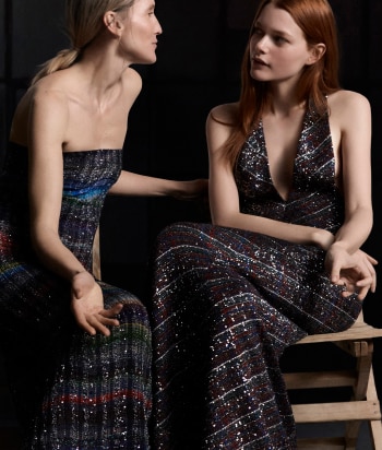 A model is wearing a strapless short dress in brown tones