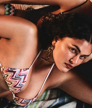 A model is wearing a sparkling jacket in dark tones