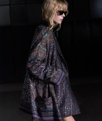 A model is wearing a sleeveless tank top and a pair of trousers, both in zig zag textures