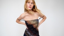 A model is wearing a strapless short dress in brown tones