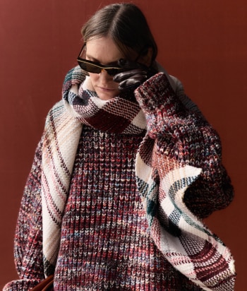 A model is wearing a sparkling jacket in dark tones
