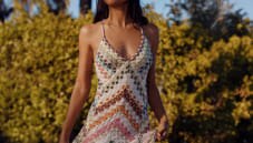 A woman is wearing a zig zag knitwear in pink tones