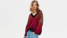 A woman is wearing a zig zag knitwear in pink tones