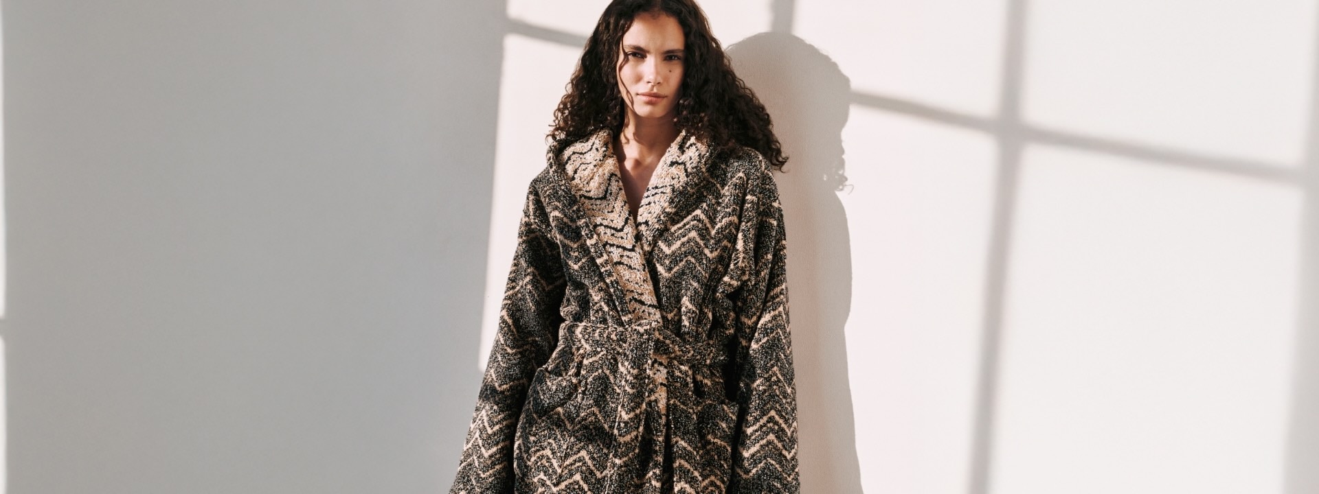 A model is wearing a zig zag brown bathrobe