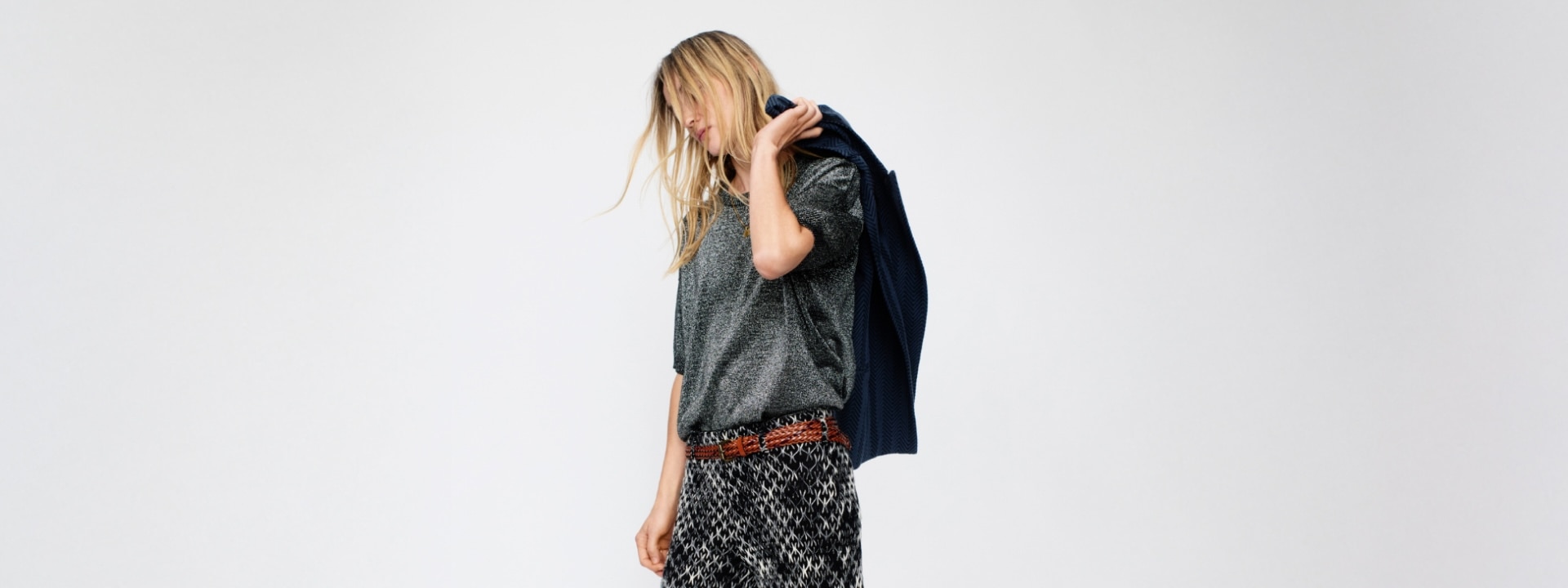 A model is wearing a blue jacket with a sparkling grey jumper