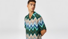 A model is wearing a zip polo in blue tones