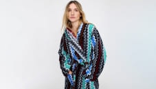 A model is wearing a blue and black zig zag bathrobe